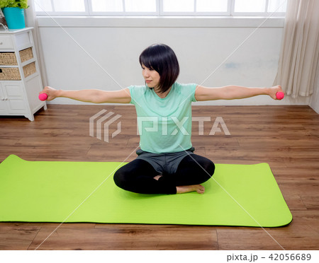 Young girl lifting dumbbells  42056689