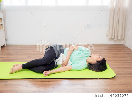 Young woman practicing yoga, lying on green mat. Young woman practicing yoga, lying on green mat. 42057075
