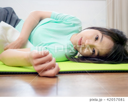 Young woman practicing yoga, lying on green mat. 42057081