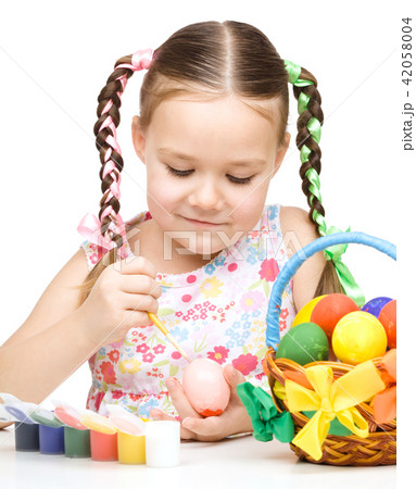 Little girl is painting eggs preparing for Easter Little girl is painting eggs preparing for Easter 42058004