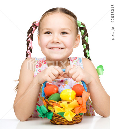 Little girl with basket full of colorful eggs 42058018