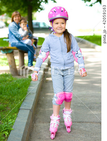 Happy little girl is skating on rollers Happy little girl is skating on rollers 42059163