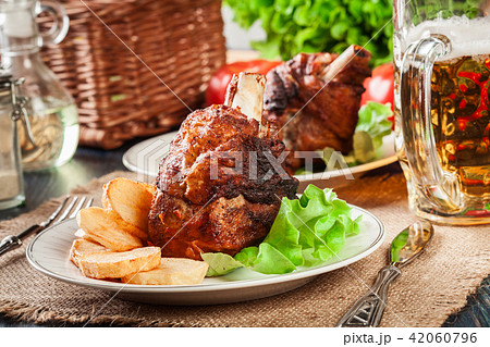 Roasted turkey knuckle with fried potato slices Roasted turkey knuckle with fried potato slices 42060796