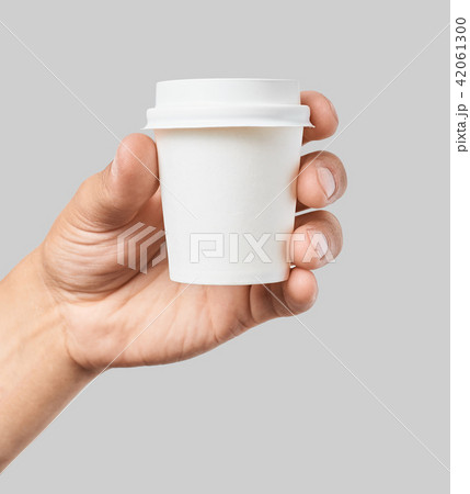 Mockup of men's hand holding white paper espresso cup with white cover 42061300