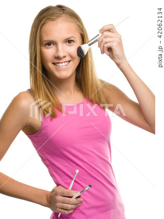 Teen girl is applying makeup 42062134