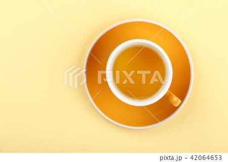 Yellow cup of green oolong tea on saucer 42064653