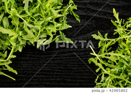Fresh Raw Arugula (rucola) on black wood 42065802