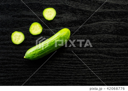 Fresh raw mini cucumber on black wood Fresh raw mini cucumber on black wood 42068776