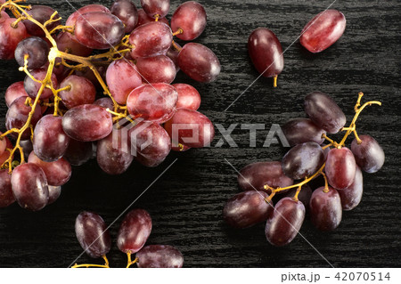 Raw fresh red globe grape on black wood Raw fresh red globe grape on black wood 42070514