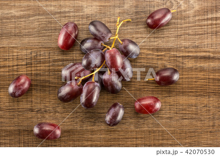 Raw fresh red globe grape on brown wood 42070530
