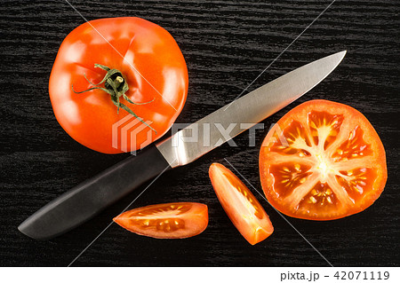 Fresh raw Tomato (La Parcela) on black wood Fresh raw Tomato (La Parcela) on black wood 42071119