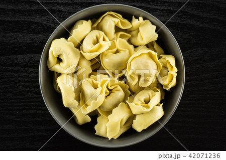 Fresh Raw tortellini pasta on black wood Fresh Raw tortellini pasta on black wood 42071236