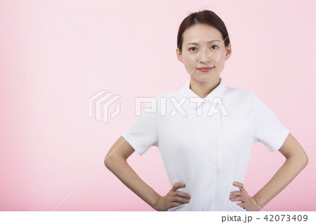 腰に手を当てて微笑む白衣の女性 42073409