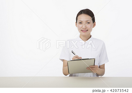 微笑みながらメモを取る白衣を着た女性 42073542