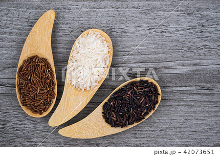 Thai Jasmine white and black rice in wooden spoons Thai Jasmine white and black rice in wooden spoons 42073651