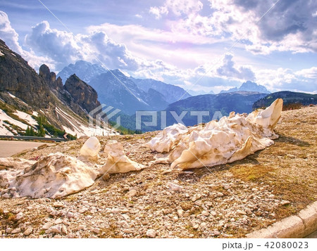 Melting snow at gravel road in spring mountains 42080023