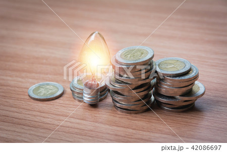 Energy saving light bulb and tree growing on stack 42086697