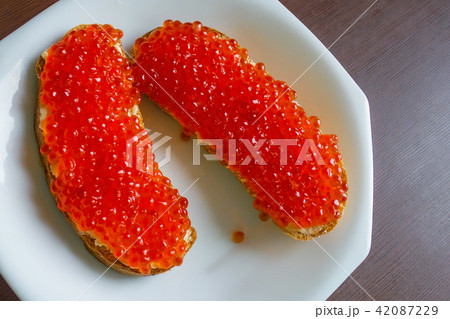 Two sandwiches with salmon caviar. 42087229