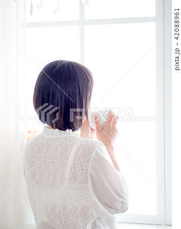 woman standing in front of window and drink coffee woman standing in front of window and drink coffee 42088961