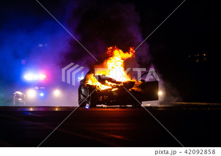 Car on fire at night with police lights 42092858