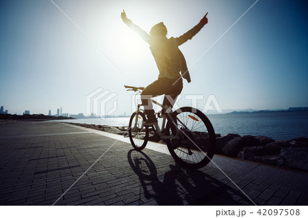 cyclist riding bike in the sunrise coast road cyclist riding bike in the sunrise coast road 42097508