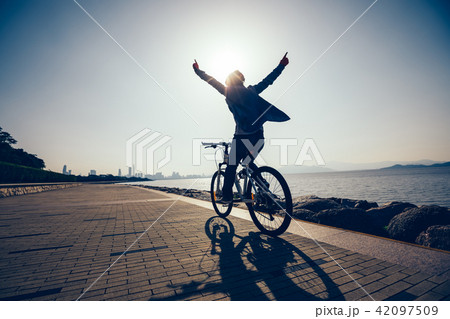 happy cyclist riding bike in the sunrise coast happy cyclist riding bike in the sunrise coast 42097509