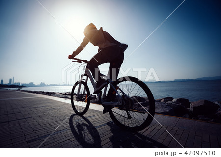 cyclist riding bike in the sunrise coast road cyclist riding bike in the sunrise coast road 42097510