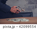 Mafia holding gun with ammunition and money 42099554