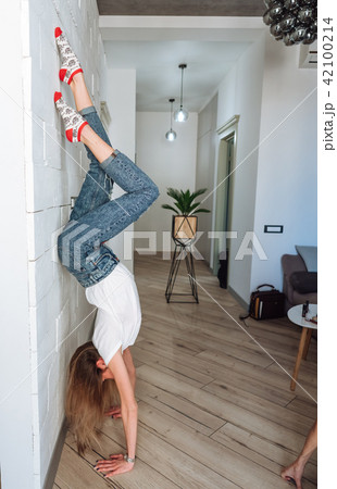 A woman is standing on his hands upside down A woman is standing on his hands upside down 42100214