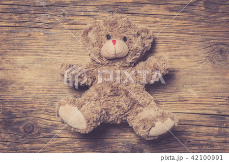 Brown teddy bear over wooden background 42100991