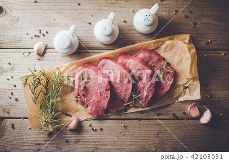 Raw beef steak on wooden table 42103031
