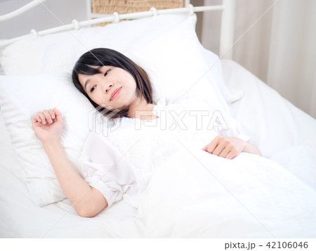Young woman lying in bed at home in the bedroom 42106046