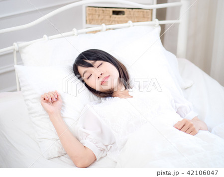 Young woman lying in bed at home in the bedroom 42106047
