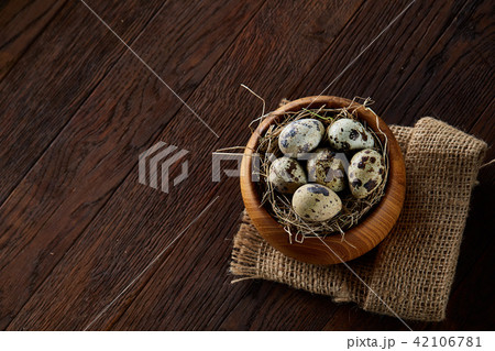 Rural still life with bowl full of eggs quail, eggs on a homespun napkin, boxwood on wooden Rural still life with bowl full of eggs quail, eggs on a homespun napkin, boxwood on wooden 42106781