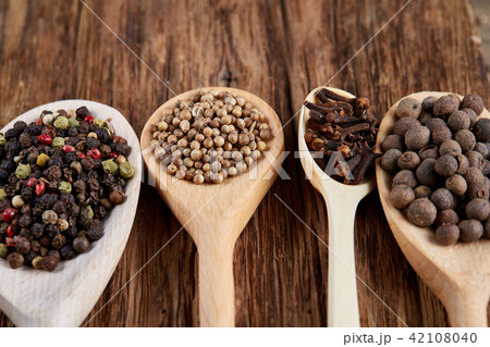 Row of wooden spoons with spices on vintage background, diminishing perspective, close-up, selective Row of wooden spoons with spices on vintage background, diminishing perspective, close-up, selective 42108040