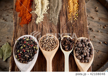 Row of wooden spoons with spices on vintage background, diminishing perspective, close-up, selective Row of wooden spoons with spices on vintage background, diminishing perspective, close-up, selective 42108046