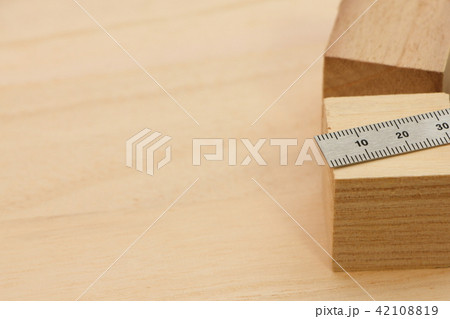 木の板の上に置かれた立方体の木材と金属製の定規(直尺)。 42108819