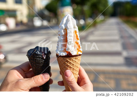 A first person view, sweethearts walking along the road with an ice cream in their hands, shallow 42109202