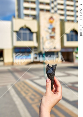 A first person view, a person walking along the road with an ice cream in his hands, shallow depth A first person view, a person walking along the road with an ice cream in his hands, shallow depth 42109213