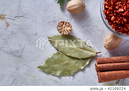 Bay leaf, nutmeg and cinnamon on white textured background, top view, close-up, selective focus. 42109224