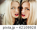 portrait of beautiful young woman blonde girl and her reflection in mirror. 42109928