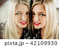 portrait of beautiful young woman blonde girl and her reflection in mirror. 42109930