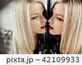 portrait of beautiful young woman blonde girl and her reflection in mirror. 42109933