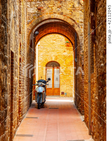 Old medieval street of San Gimignano with small motorcycle, Tuscany, Italia Old medieval street of San Gimignano with small motorcycle, Tuscany, Italia 42112045