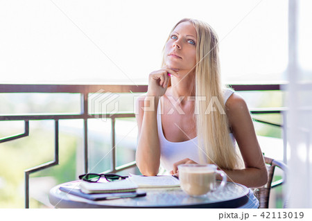 woman drink coffee and writing note book journal 42113019