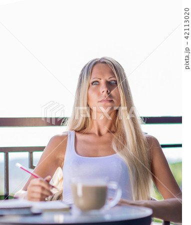 woman drink coffee and writing note book journal 42113020