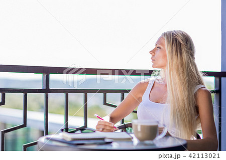 woman drink coffee and writing note book journal 42113021