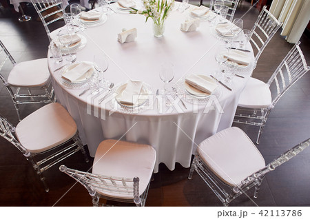 Classic table setting. White tablecloth, glasses, knife and fork. Ease.Round table. Top view Classic table setting. White tablecloth, glasses, knife and fork. Ease.Round table. Top view 42113786