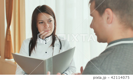 A patient guy and a young girl doctor gives advice in a hospital. 42114075