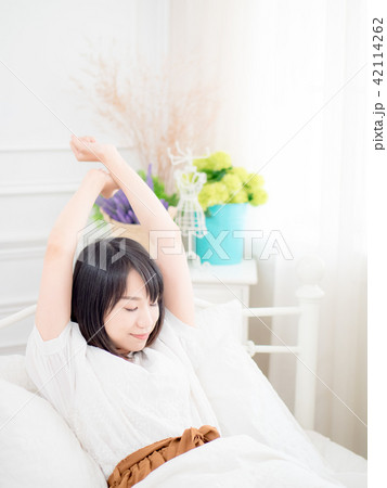 girl waking up stretching arms on the bed girl waking up stretching arms on the bed 42114262